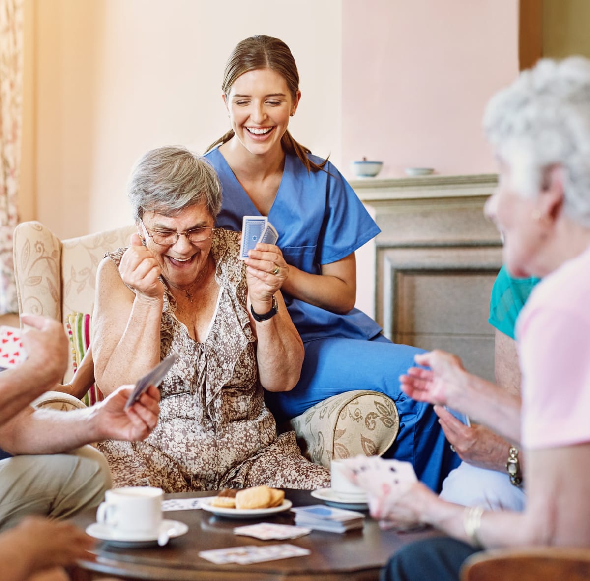 Betreuungskraft spielt Karten mit Seniorinnen und Senioren – Seniorenbetreuung in Köln